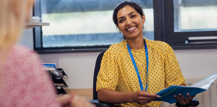 A female staff member smiling at a colleague.