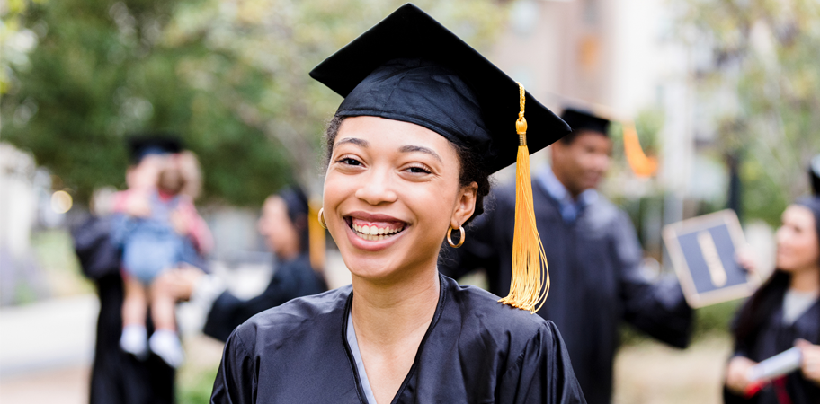 After graduation ceremony, woman smiles for photo