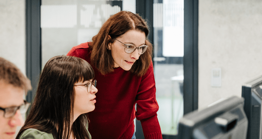 Two colleagues work together at a computer.