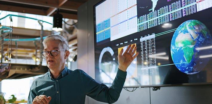 Man conducting a seminar in front of a large screen
