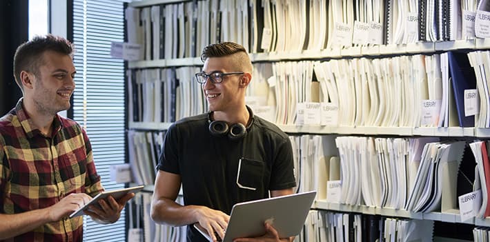 Two staff members in a university library.