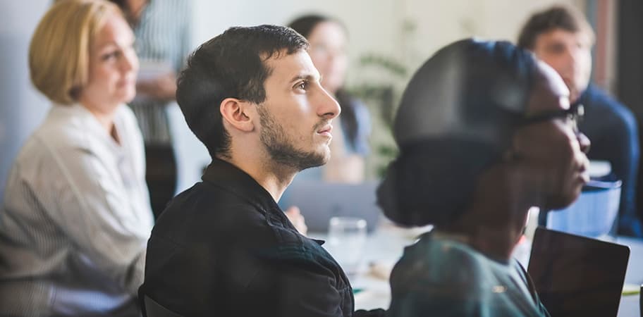 A male member of staff watching a presentation.