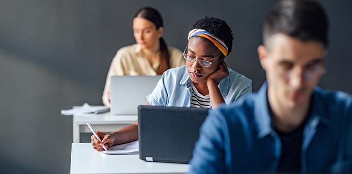 Three students working on laptops