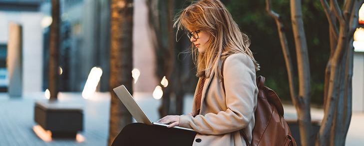 Student using laptop outside university campus
