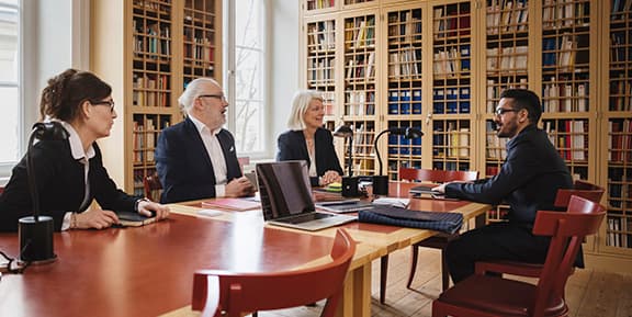 A team of university executives sitting in a meeting room.