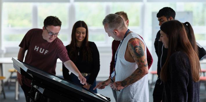 University colleagues and students using technology in the classroom.