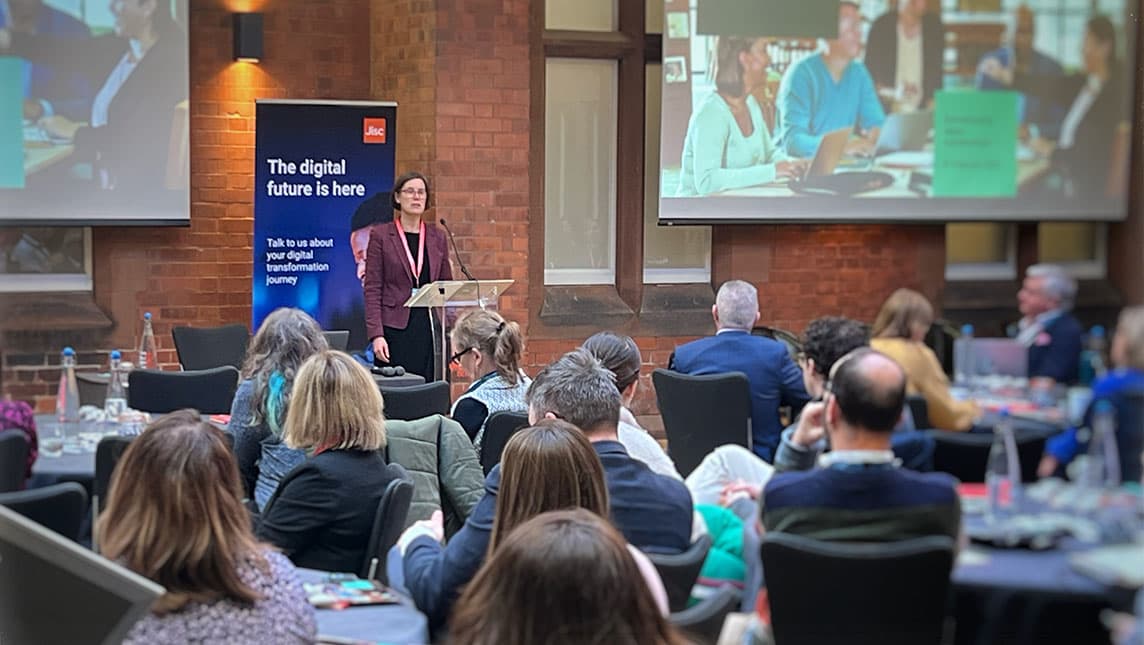 A woman giving a presentation in front of an audience.