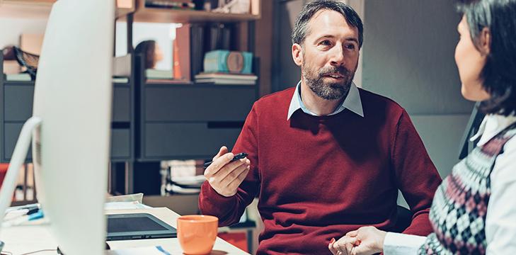 Researchers sitting at a desktop computer.