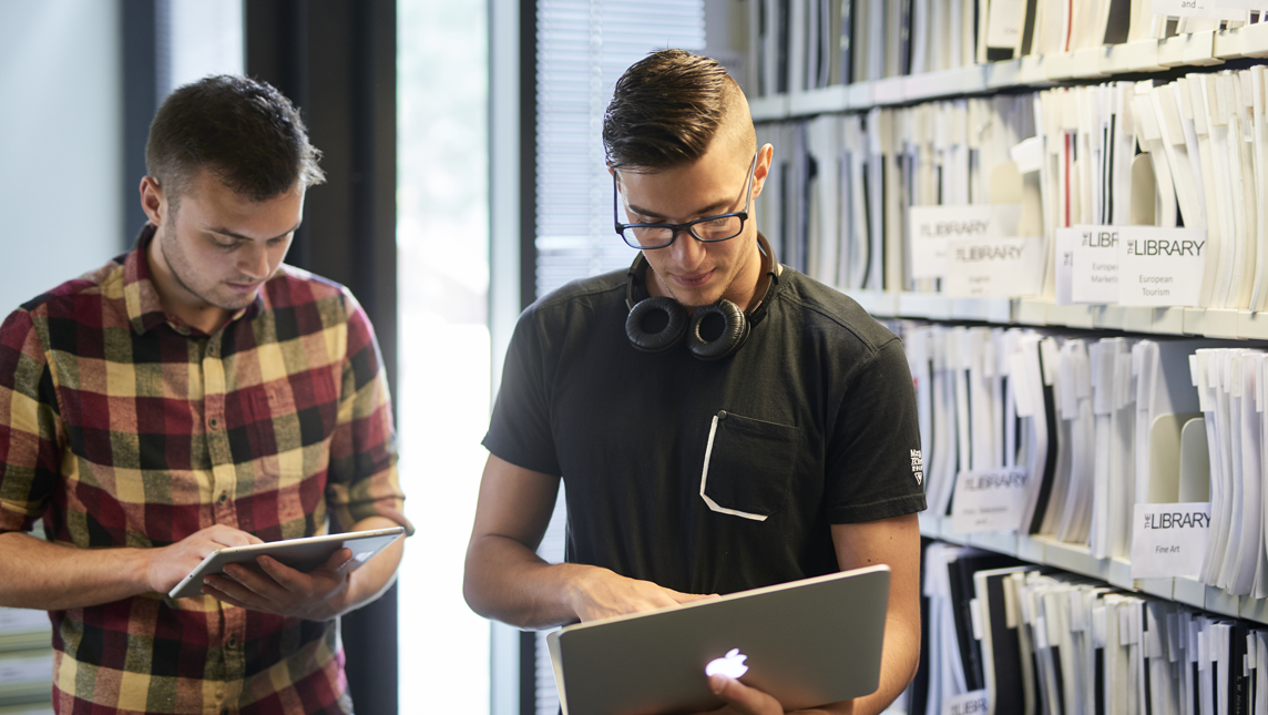 Students work on laptops in a university library