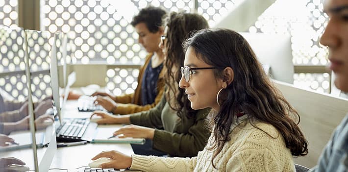 Students sitting at a table with computers