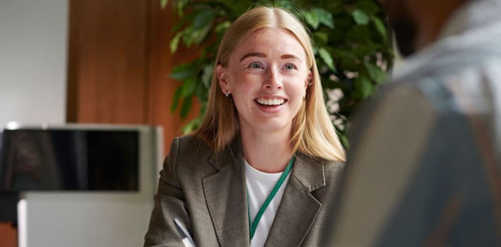 A woman talks with her colleague in an office.